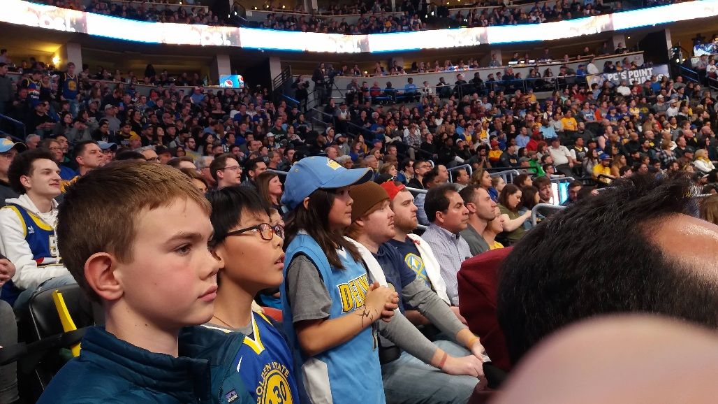 Tianqiqi in a Warriors jersey watching a game from the stands